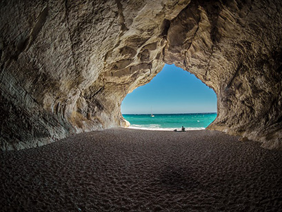 the sea and sky as seen from inside a cave